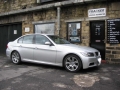 BMW 320d.  Screen installation into headrest with cordless headphone. Single DVD player installed into centre armrest.