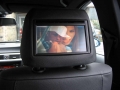 BMW 320d.  Screen installation into headrest with cordless headphone. Single DVD player installed into centre armrest.
