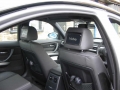 BMW 320d.  Screen installation into headrest with cordless headphone. Single DVD player installed into centre armrest.