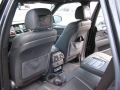 BMW X5. Two Screens trimmed into standard headrest. Single DVD player installed into rear of console. Cordless headphones.