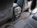 BMW X5. Two Screens trimmed into standard headrest. Single DVD player installed into rear of console. Cordless headphones.