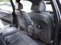 BMW X5. Two Screens trimmed into standard headrest. Single DVD player installed into rear of console. Cordless headphones.