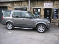 Land Rover Discovery 4. Two screens trimmed into standard headrest. Single DVD player installed into rear on centre console replacing cup holders. Cordless headphones.