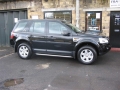 Land Rover Freelander 2. Two screens trimmed into standard headrest. Single DVD player installed under passenger seat allowing access from front. Cordless headphones.