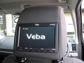Land Rover Freelander 2. Two screens trimmed into standard headrest. Single DVD player installed under passenger seat allowing access from front. Cordless headphones.